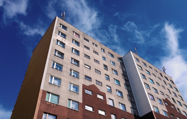 brown concrete apartment building against a blue sky